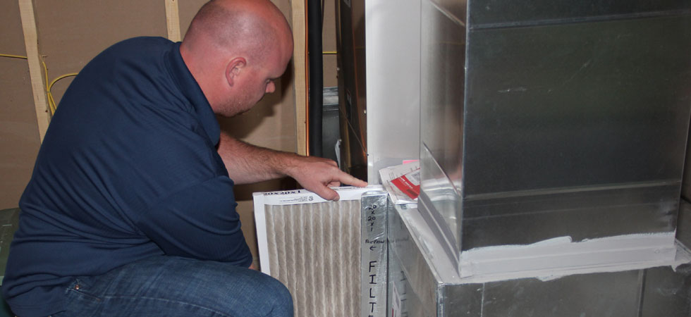 Man replacing furnace filter