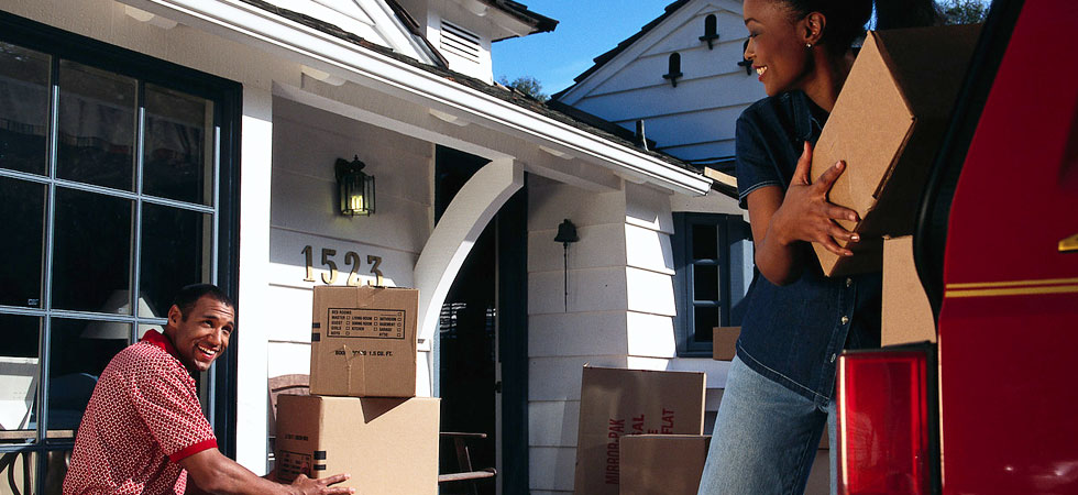 couple packing moving boxes into vehicle