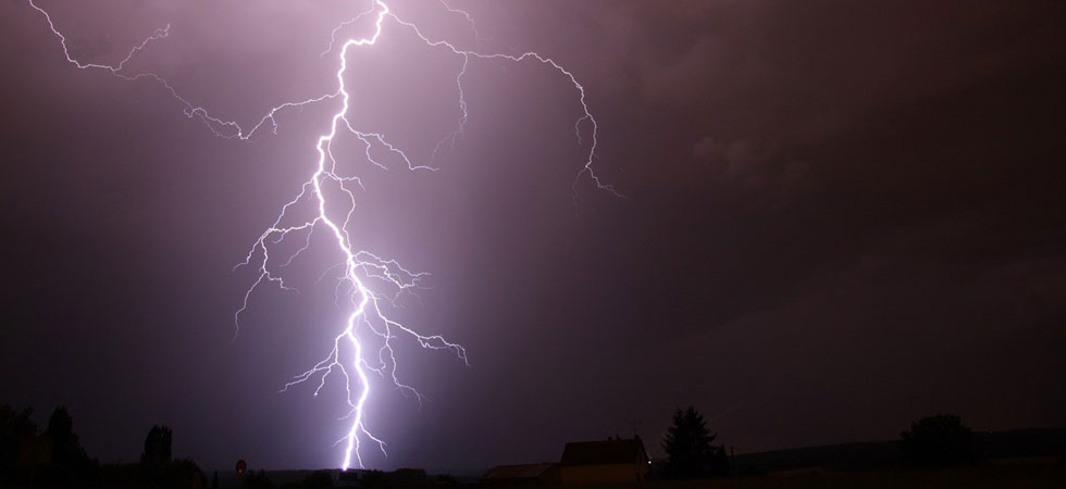 Lightning striking ground in night sky